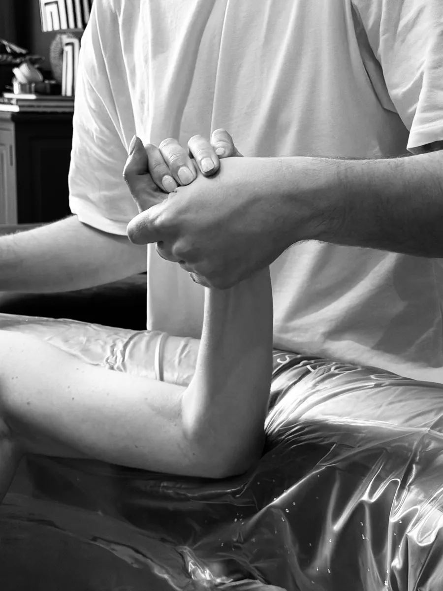 Een partner houdt tijdens de bevalling stevig de hand van een barende vrouw vast